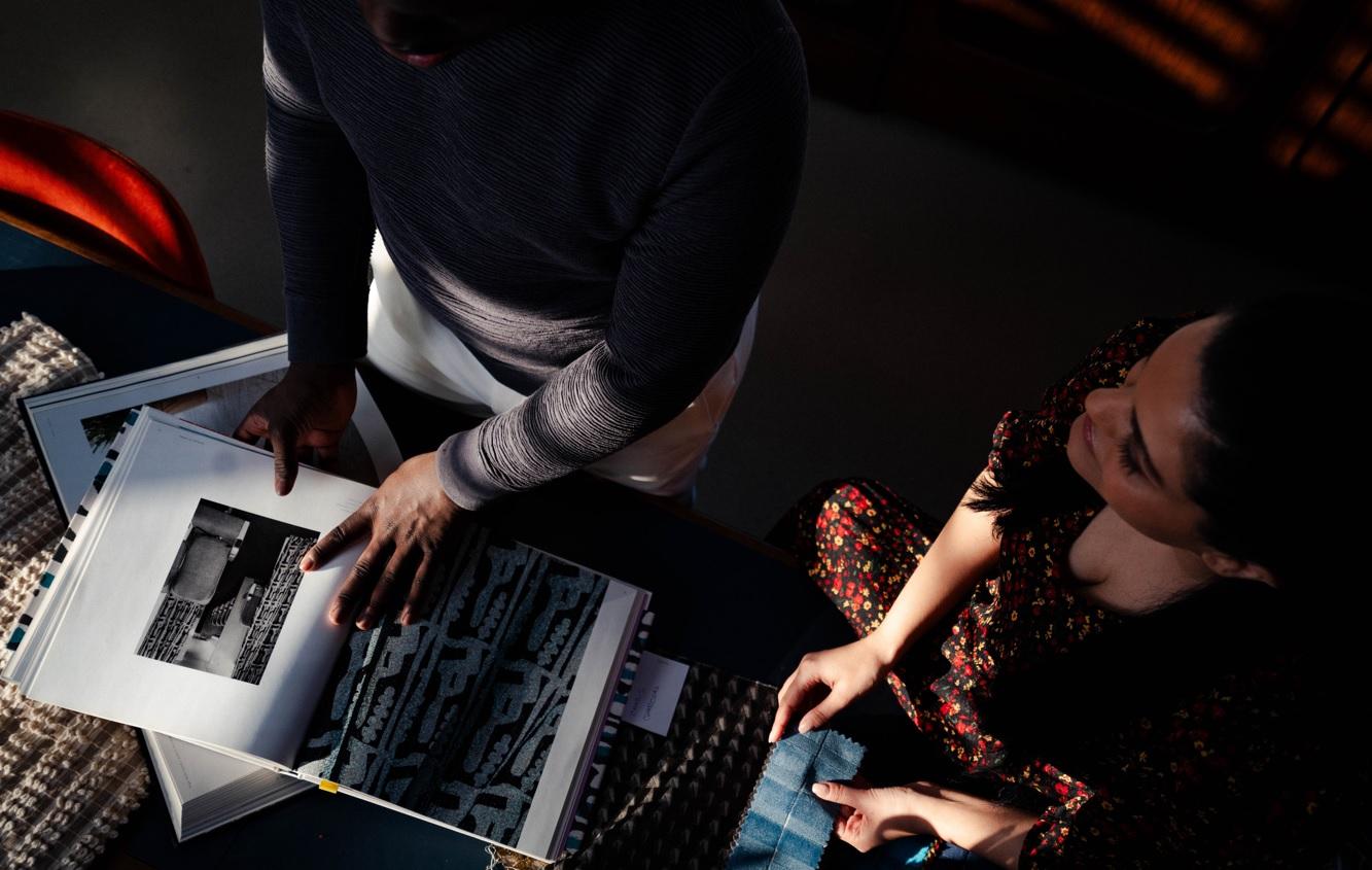 image shows overhead shot of team members reviewing designs and fabrics